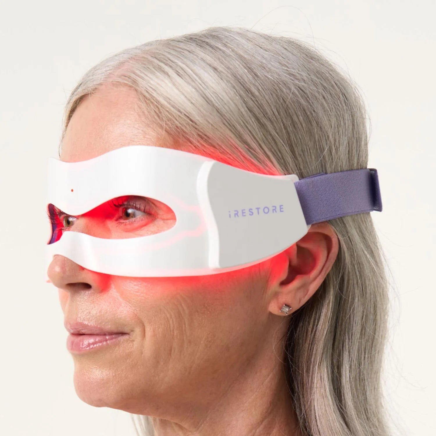 Close up side view shot of woman's face wearing the LED eye mask