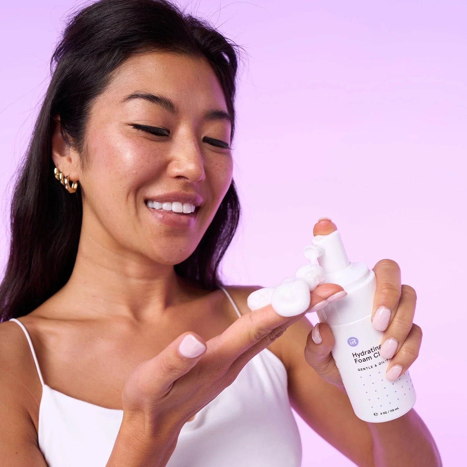 Woman putting hydrating foam cleanser on hand