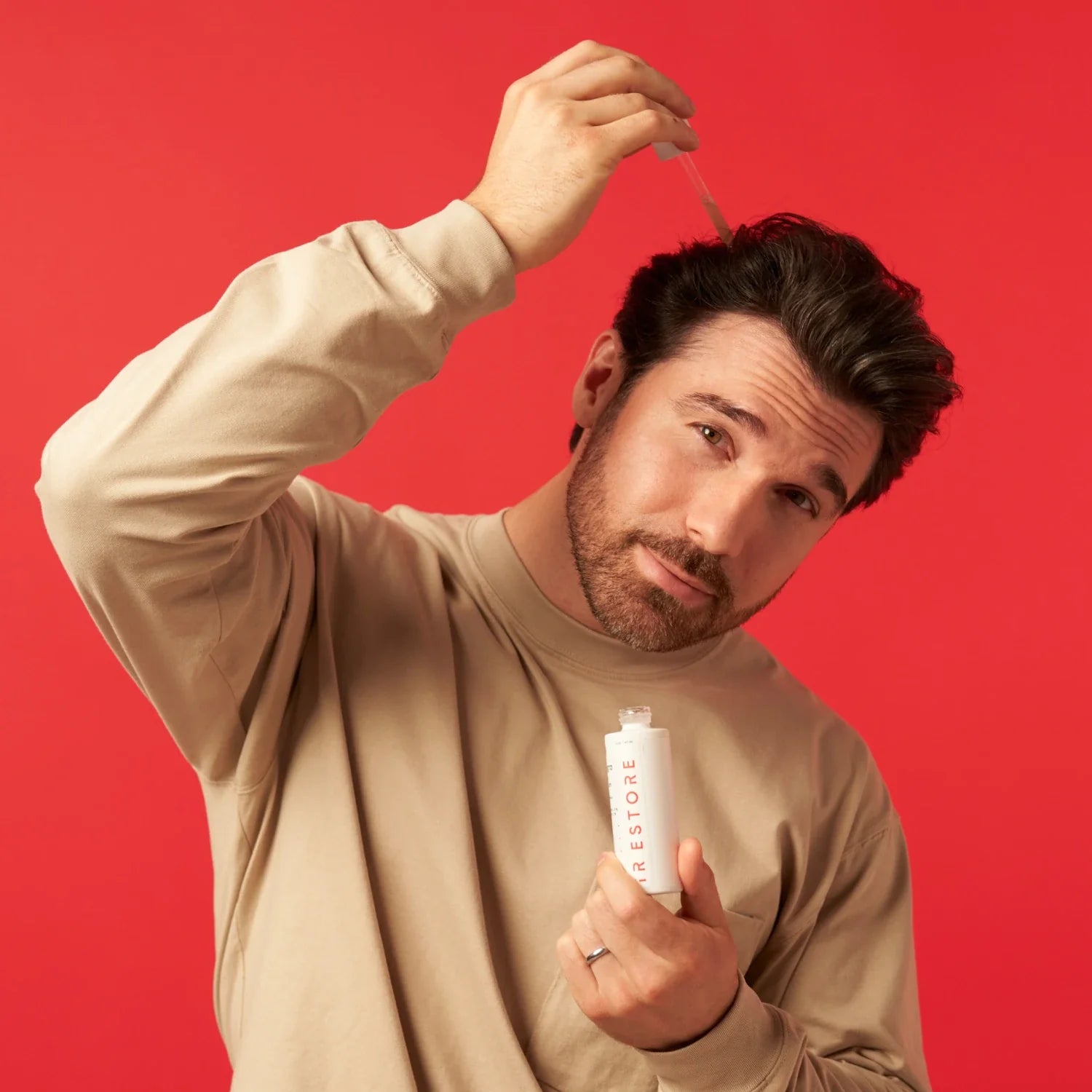 Man putting drops of growth activator serum in his hair