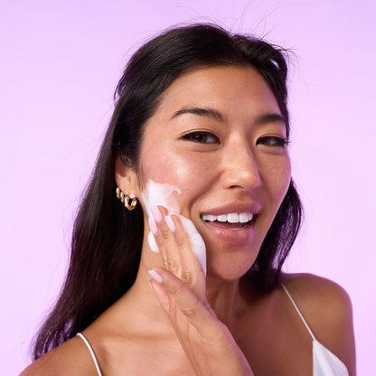 Woman rubbing the foam form hydrating foam cleanser on her face