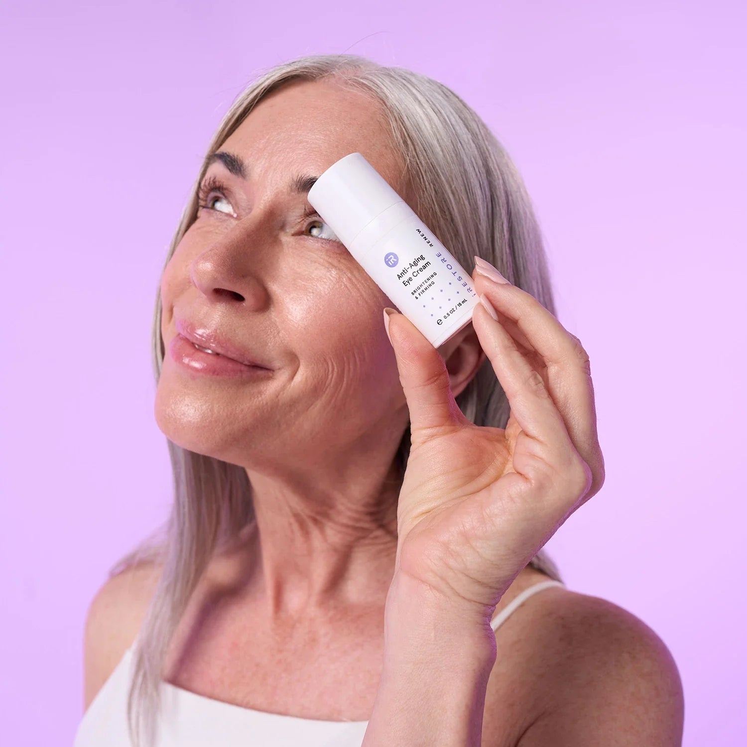 Mature woman holding the anti-aging eye cream