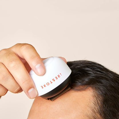 Close up shot image of a man rolling the derma roller in his scalp.
