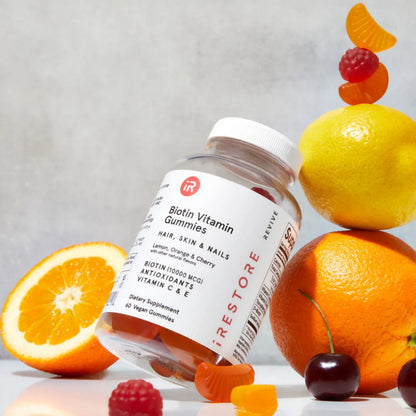 Biotin Vitamin Gummies bottle with fruits and gummies in the background