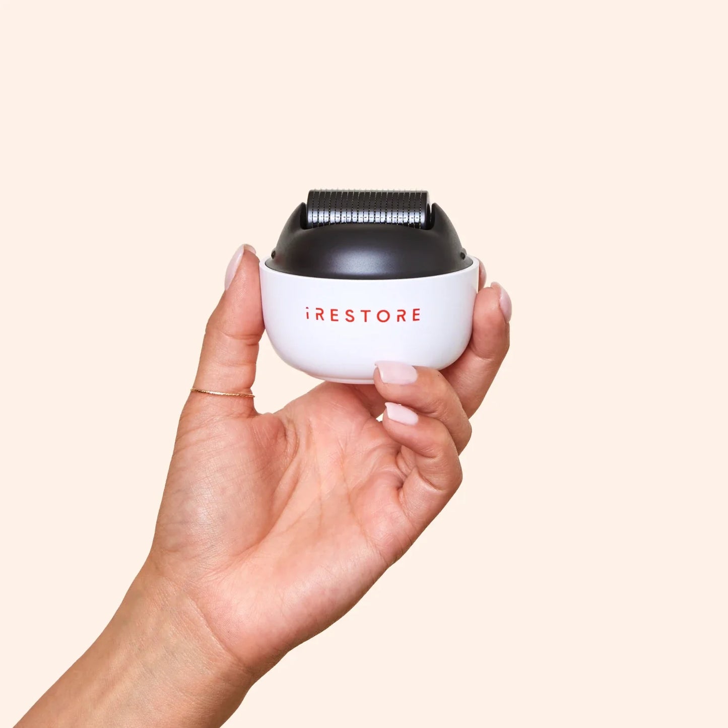 Close up shot image of a hand holding the ScalpStim Derma Roller.