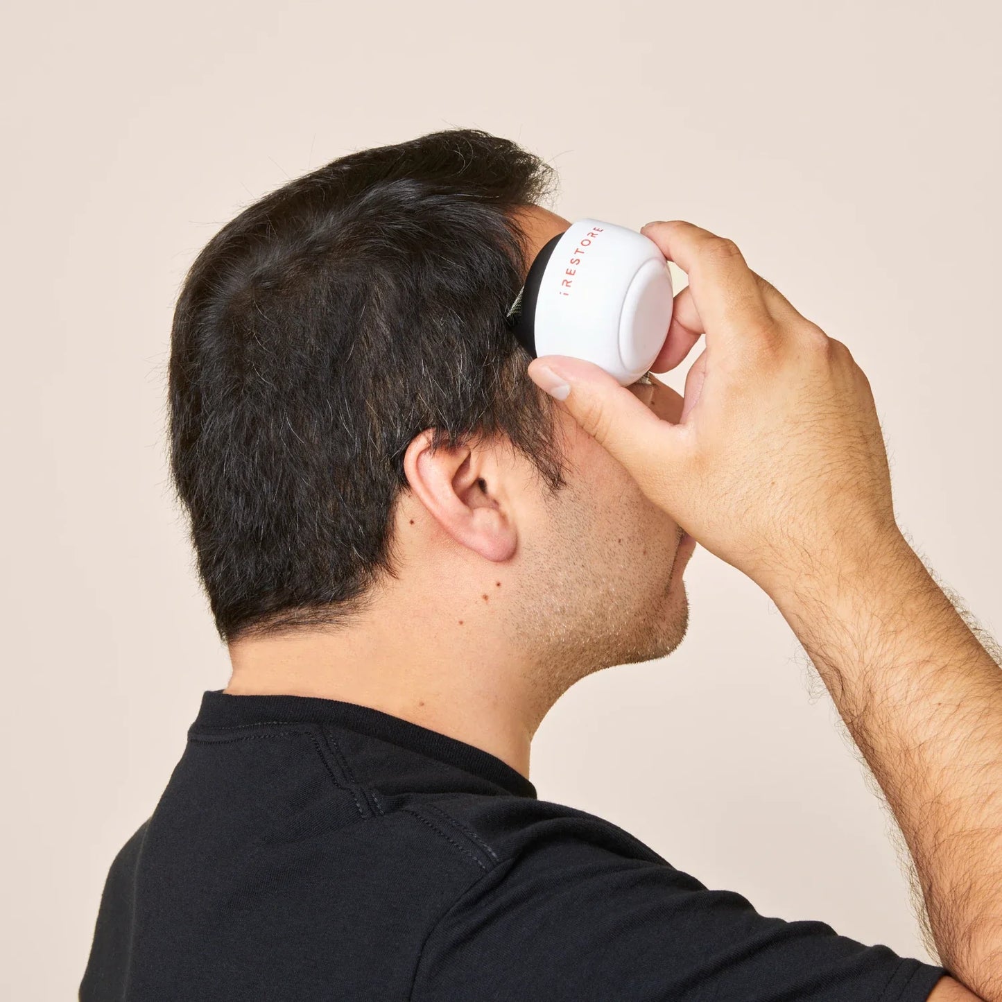 Image of a man using the derma roller in his temples.