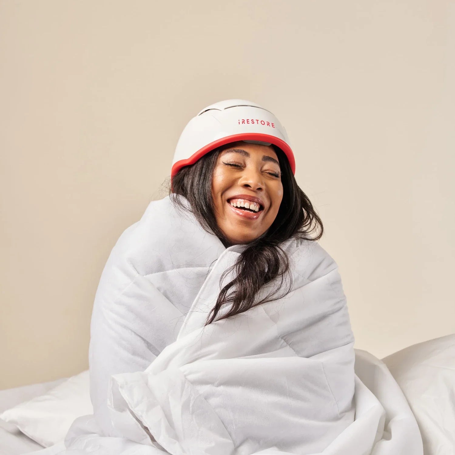 Image of a middle aged woman wearing the Professional hair device in her bed.