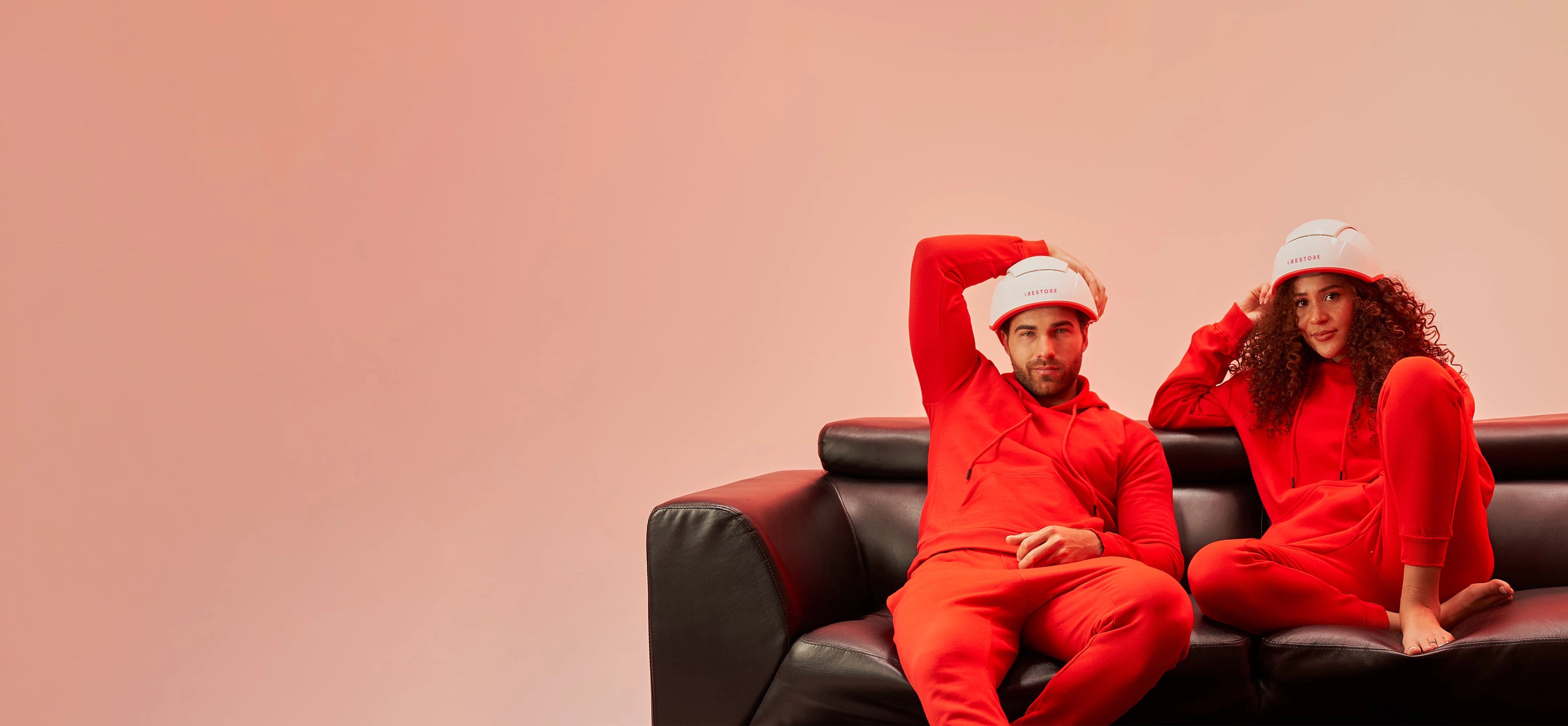 man and woman wearing irestore pro device on sofa