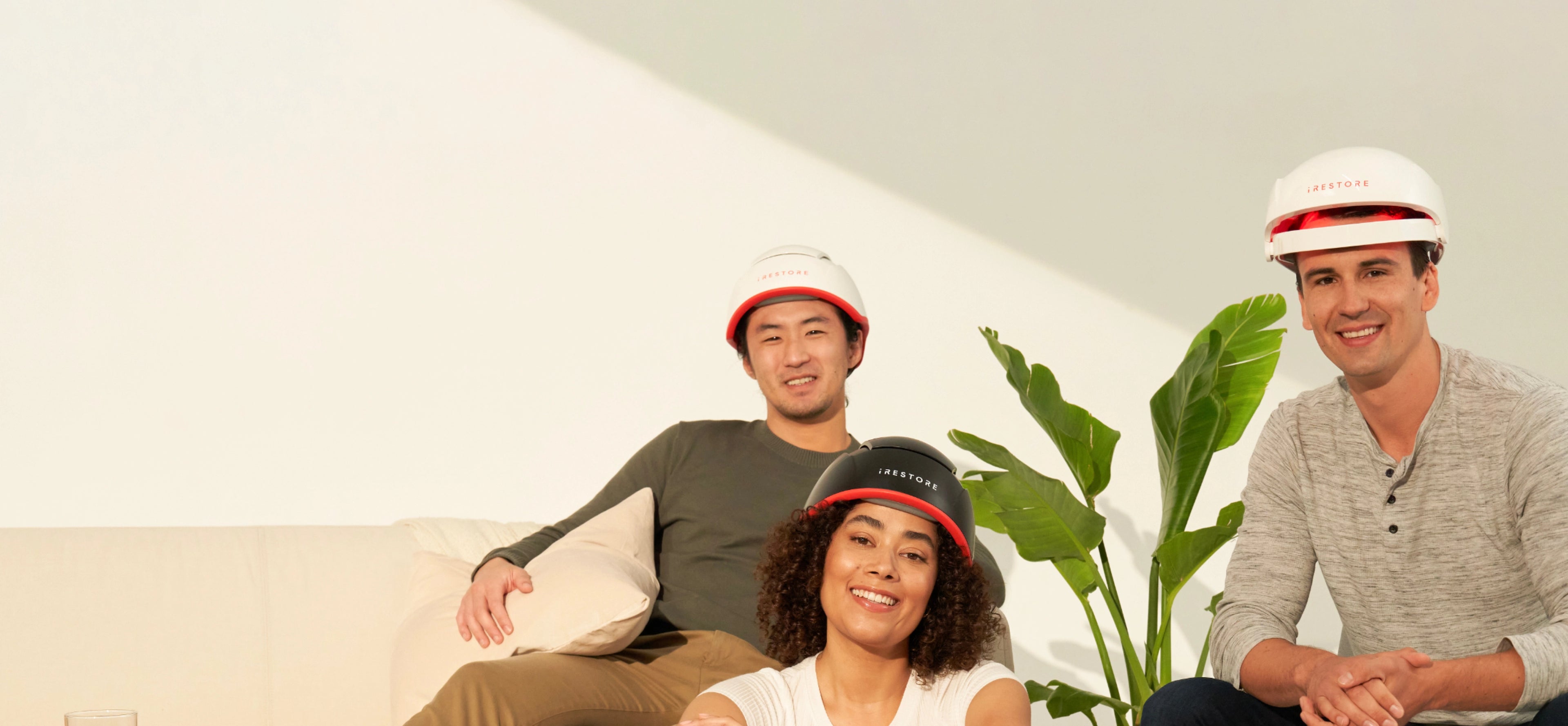 2 men and 1 woman wearing irestore devices smiling